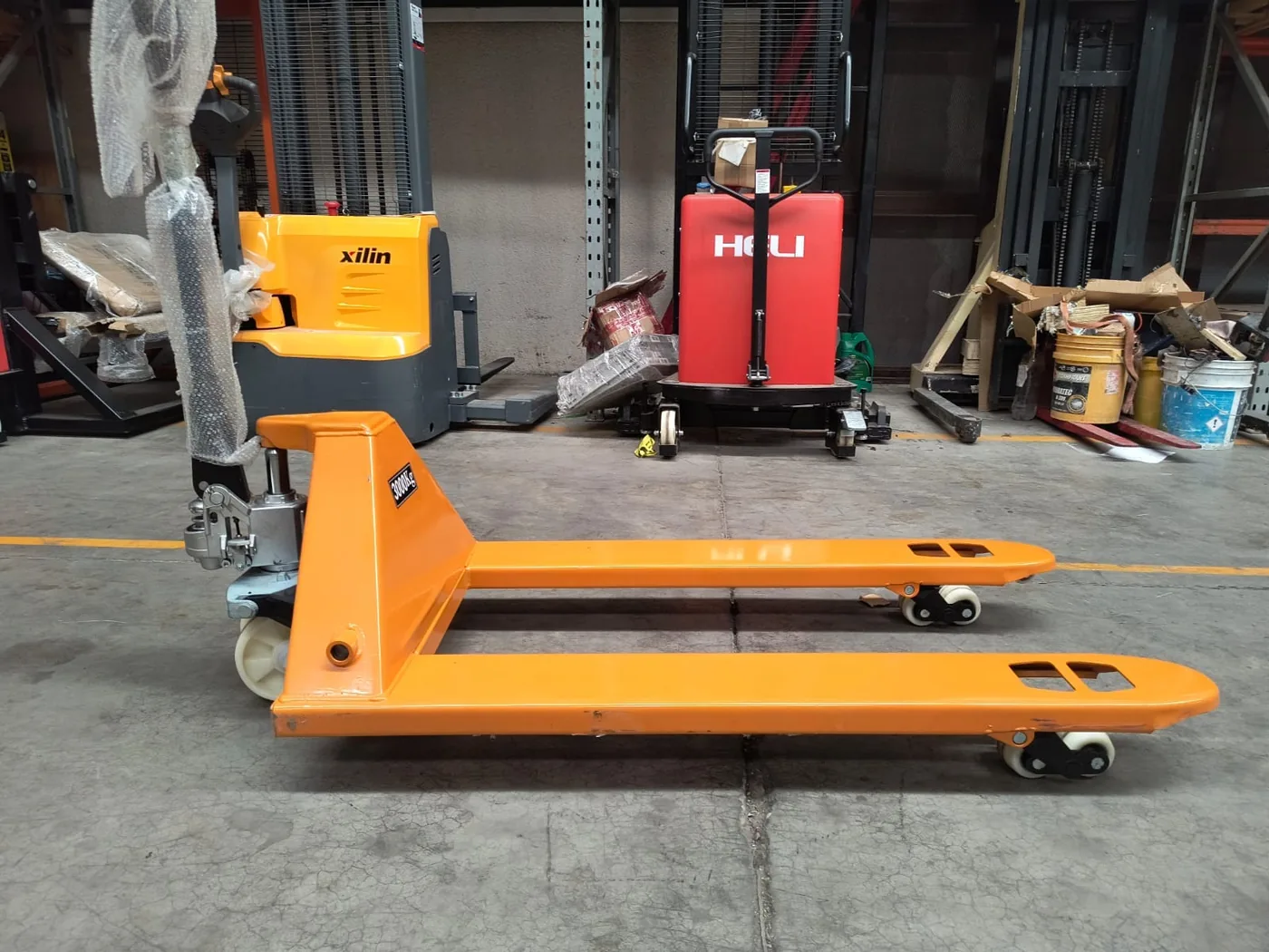 Patín hidráulico naranja Montrack de 3,000 kg en bodega